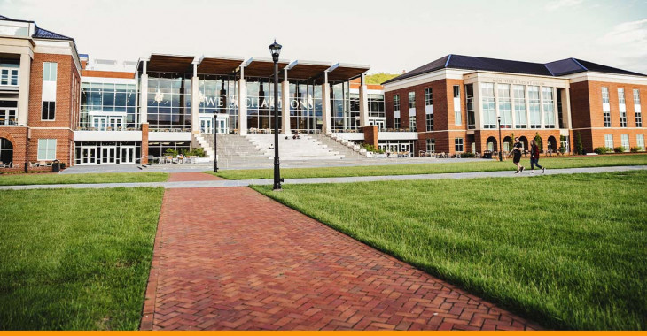 Imagem panorâmica de uma escola, com alunos andando na calçada