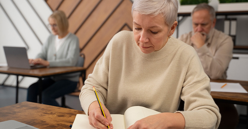 Idosos estudando em uma sala de aula.