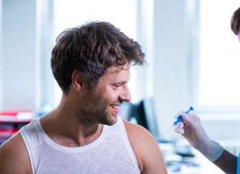 homem tomando vacina em um hospital