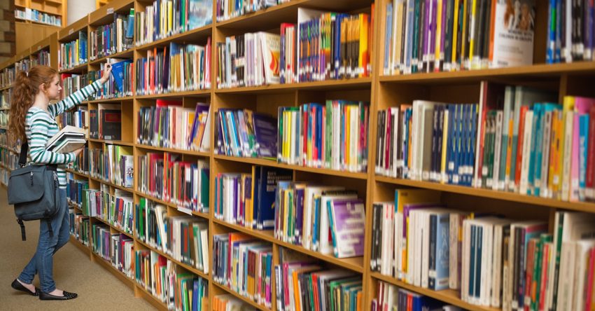 biblioteca e menina pegando um livro na prateleira