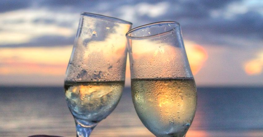 brinde de champagne em frente ao mar