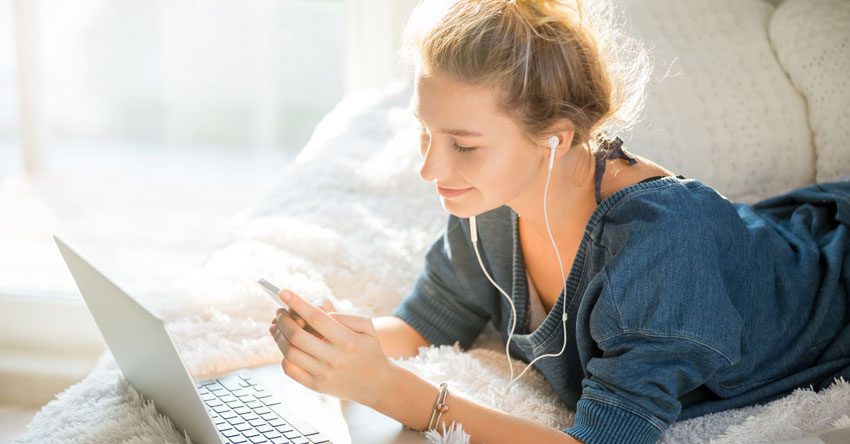 menina mexendo no celular e no computador