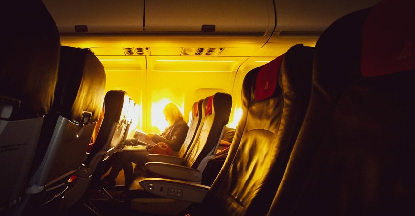 pessoa dentro de um avião com o por do sol