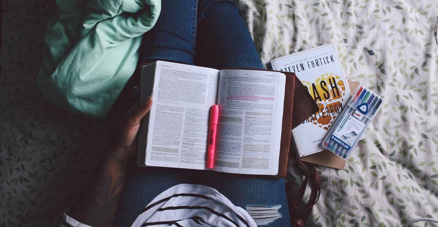 tipos de intercâmbio: pessoa estudando com o livro no colo