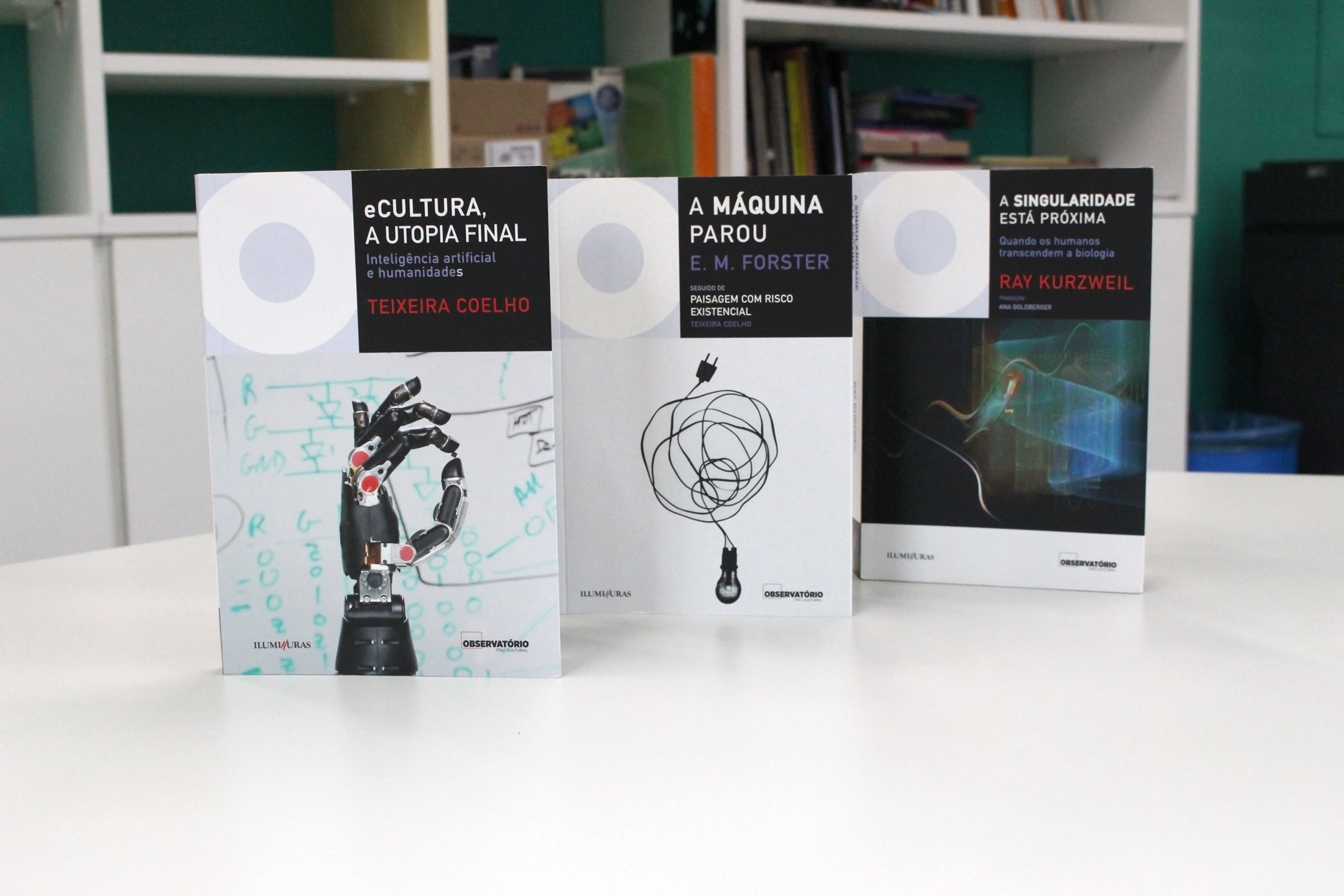 Foto com os três livros da trilogia eCultura. Na frente o livro "eCultura", ao fundo "A singularidade está próxima" e entre eles o livro "A máquina parou". 