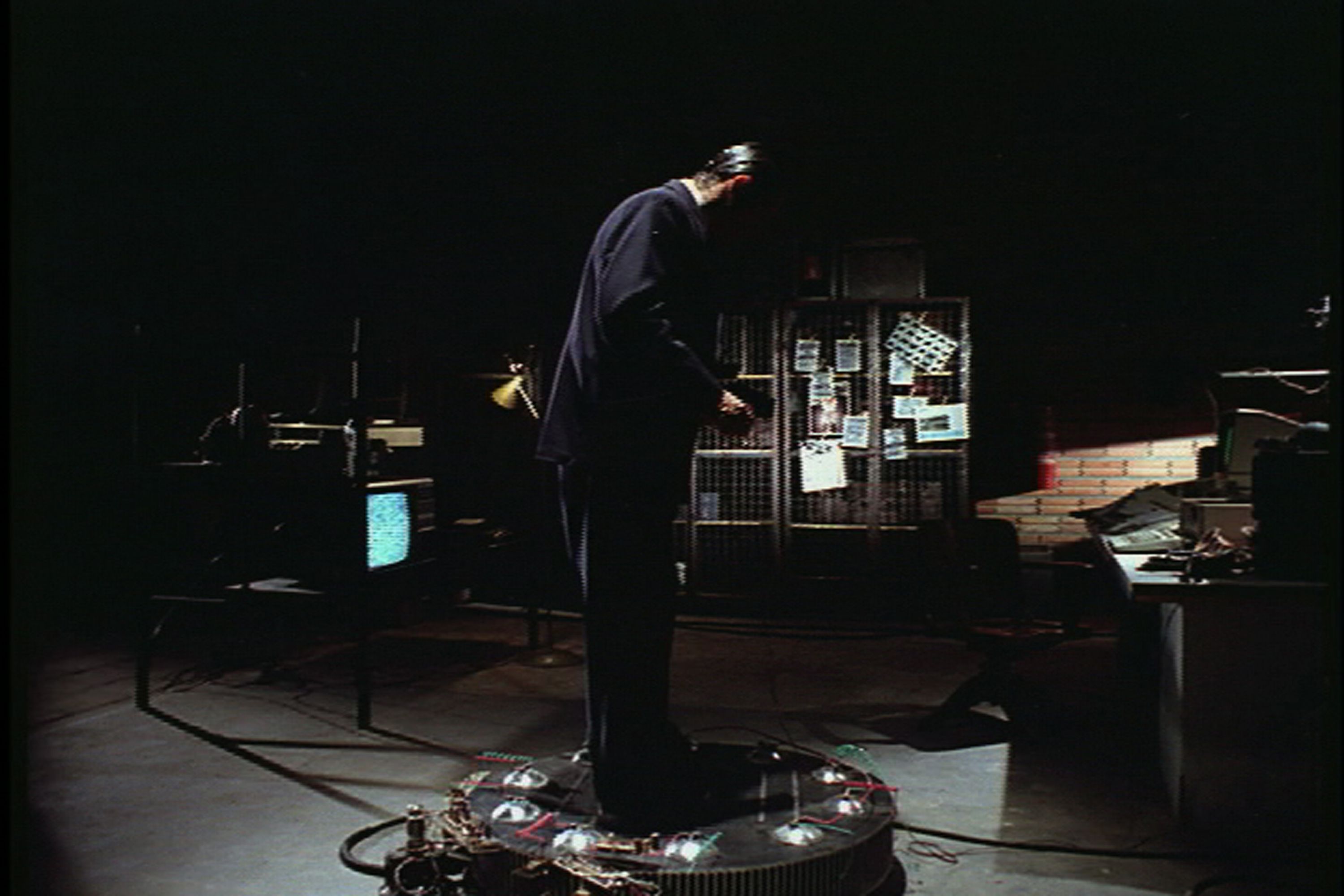 Ant&ocirc;nio Fagundes est&aacute; em uma sala escura, com um aparelho de TV e fios. Ele veste um terno preto.