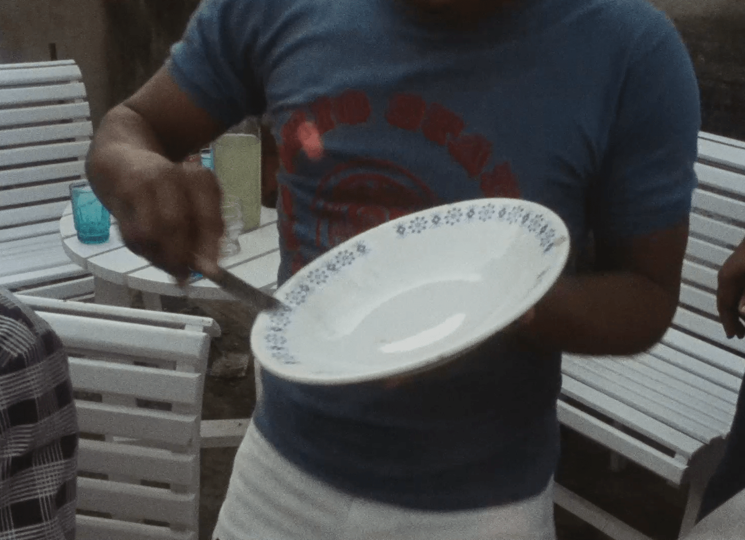 A imagem mostra um sambista tocando prato. A foto enfoca as m&atilde;os do artista, uma segurando o prato e a outra manejando uma faca.
