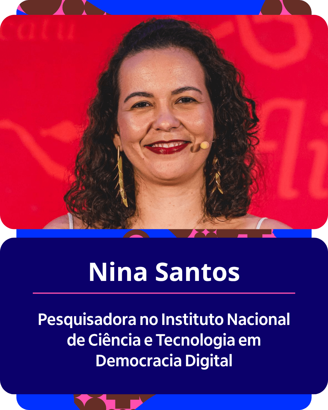 Card gráfico vertical com formato de retrato institucional.
Na metade superior, dentro de um quadro de cantos arredondados sobre fundo vermelho vibrante, há o retrato em primeiro plano de Nina Santos. Ela é uma mulher branca de cabelos escuros e cacheados na altura dos ombros. Ela sorri para a câmera com batom vermelho nos lábios, usa brincos dourados compridos em formato folhado e um microfone auricular bege preso na bochecha esquerda.
Na metade inferior, em um bloco de fundo azul-escuro com cantos arredondados, estão dispostos os textos em letras brancas centralizadas: o nome