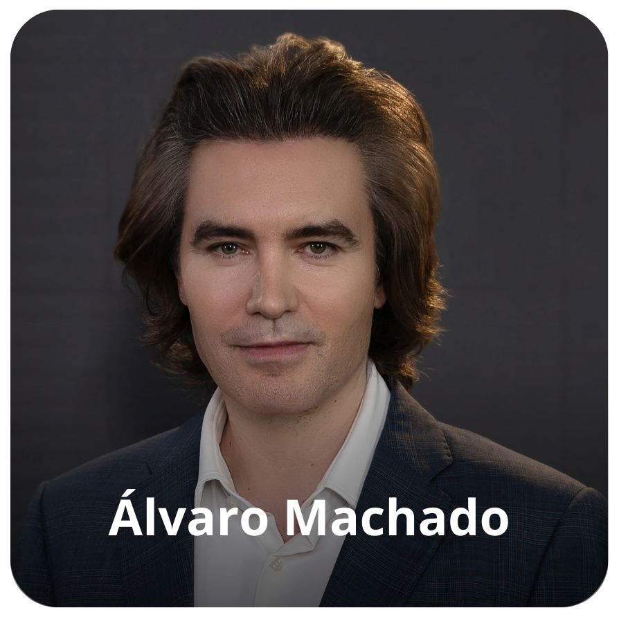 Um homem branco,, com cabelos curtos e grisalhos. Ele veste uma camisa branca  e um paleto cinza