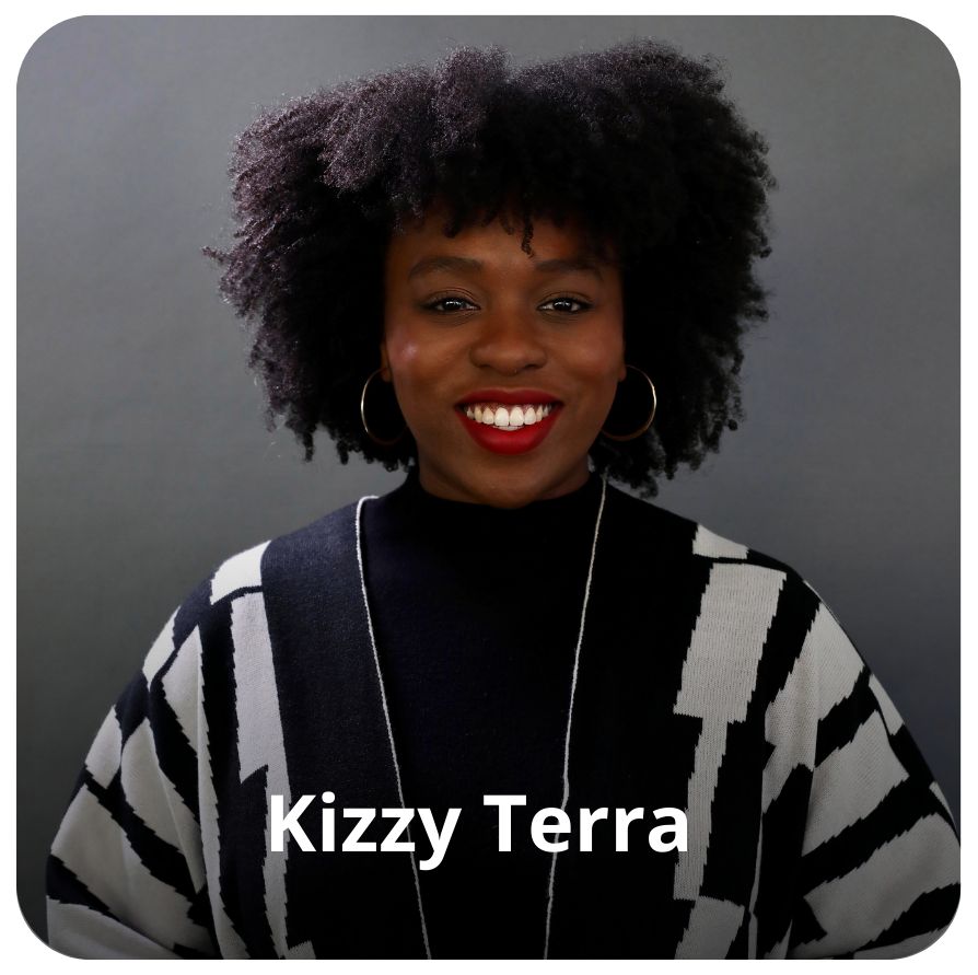 Uma mulher negra, de cabelos curtos e crespos na cor preta.  Usa batom vermelho nos l&aacute;bios  e brincos arredondados nas orelhas . Ela veste uma preta com alguns detalhes em branco nas mangas, e est&aacute; sorrindo em dire&ccedil;&atilde;o &agrave; c&acirc;mera. 