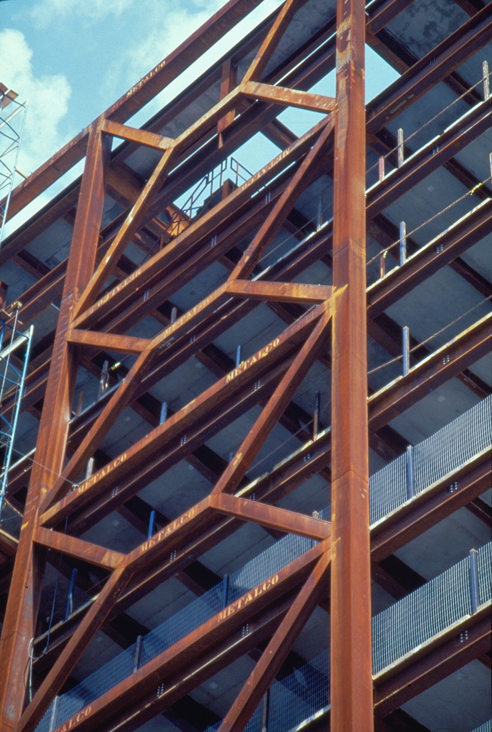 Fotografia do prédio do Itaú Cultural durante sua construção. Sua fachada frontal é caracterizada por estruturas geométricas intensas e repetitivas, semelhante a uma grelha ou elementos vazados.