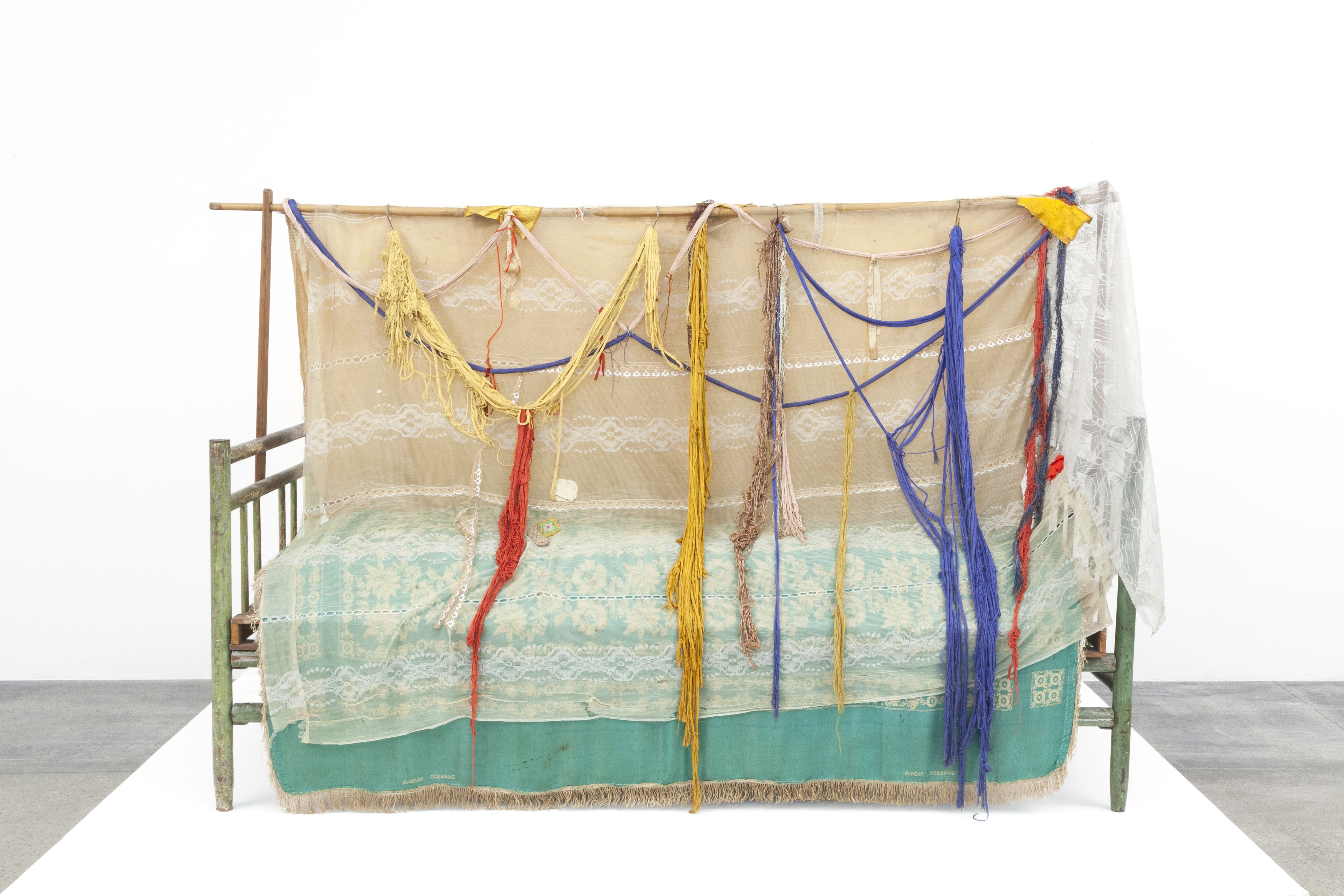 Obra do artista Bispo do Rosário, chamada Cama Romeu e Julieta. A  trata-se de uma banco em madeira, com dois tecidos cobrindo um azul e beje, e o outro branco por cima. E por cima de tudo á vários retalhos cobrindo tudo de diversas cores.  