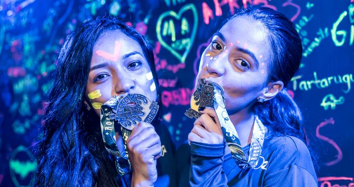 Duas atletas beijam as medalhas da Night Run Rock, realizada em São Paulo