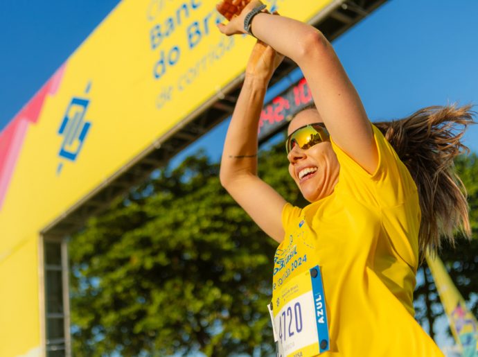 Corredora comemora ao chegar no fim da corrida